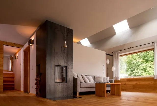 Wohnraum mit Sichtbetonkamin und Dachfenstern